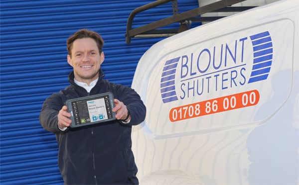 Blunt Shutters employee holding a mobile BigChange device
