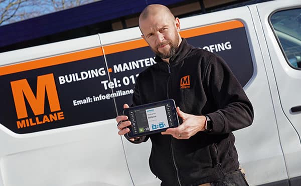Millane Contract Service employee holding a BigChange mobile device