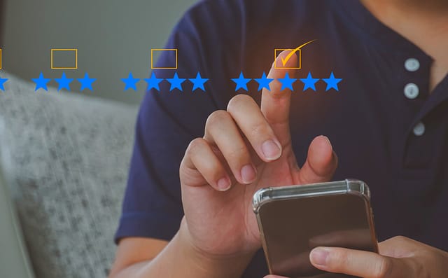 Person holding a mobile phone, selecting 5 stars